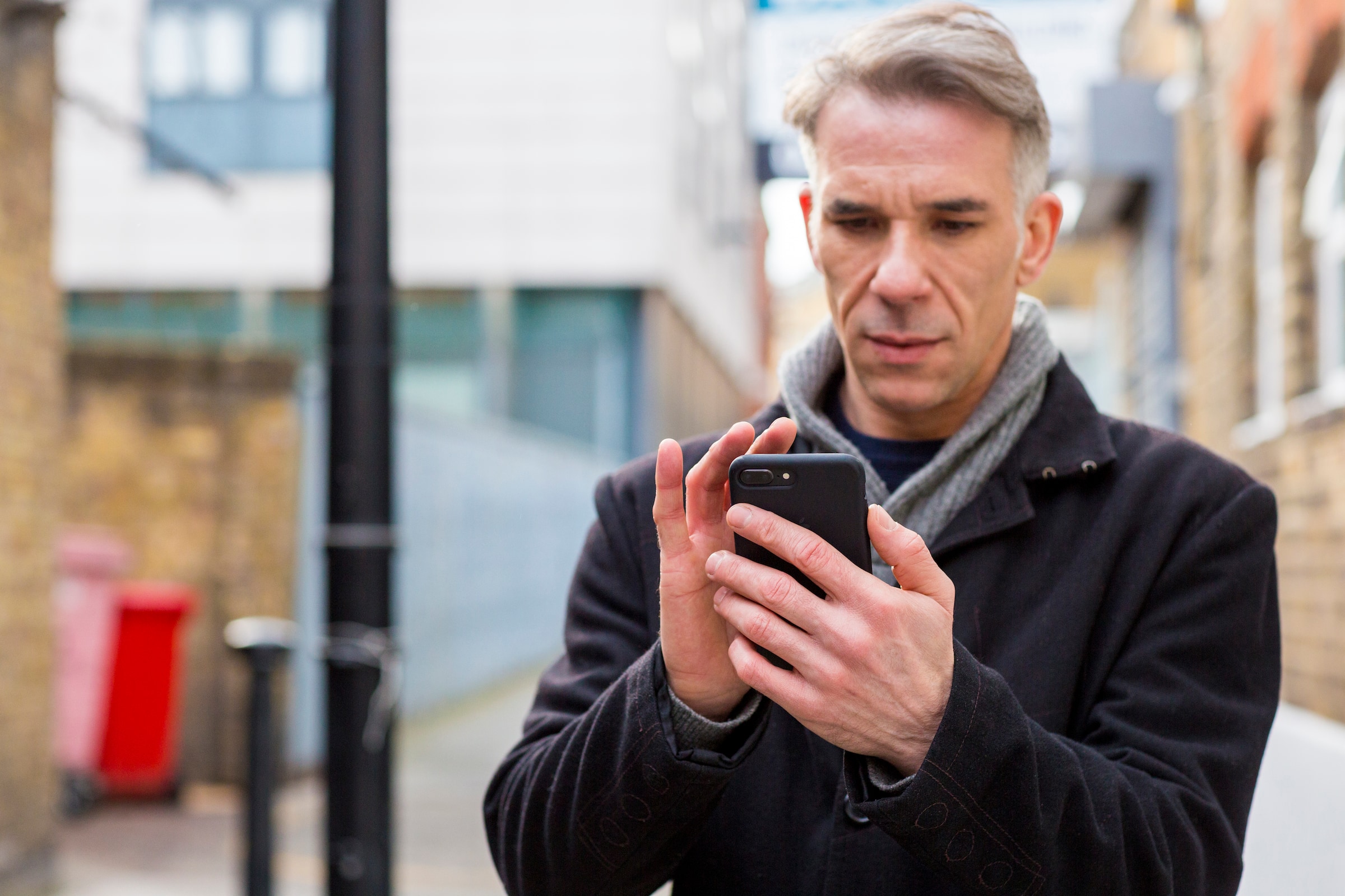 A person using a mobile phone to access Xero's estimating software built for auto repair.
